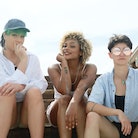 three friends pose for a photo at the beach as they consider the zodiac signs most likely to be in a...
