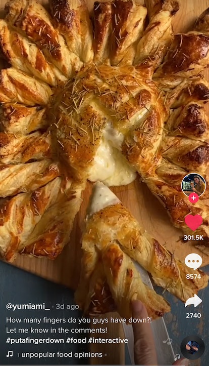 A woman cuts a slice of a sunflower baked brie recipe from TikTok